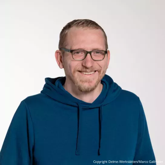 Portrait von Herrn Klassen mit schwarzer Brille und blauen Kaputzenpullover